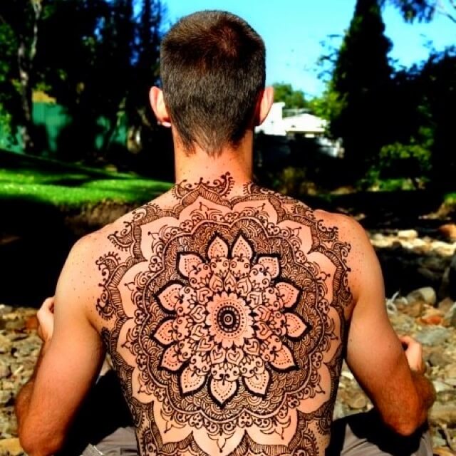 Bold tribal mehndi design on a man's wrist and forearm.